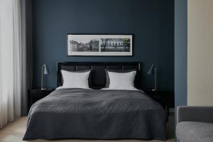 哥本哈根Avenue Hotel Copenhagen by Brøchner Hotels的一间卧室配有一张带两个白色枕头的黑色床。