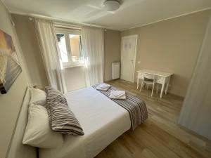 特雷维尼亚诺罗马诺Casa Vacanze Lago Blu的一间卧室设有一张床、一个窗口和一张桌子