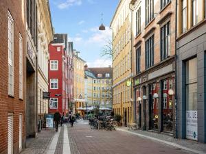 哥本哈根Sanders Leaves - Chic Three-Bedroom Apartment In Downtown Copenhagen的一条城市街道,街道上有许多建筑,人们在街上行走