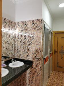 AzlaMaison d'Hôtes Casa Azla的一间带两个盥洗盆和瓷砖墙的浴室