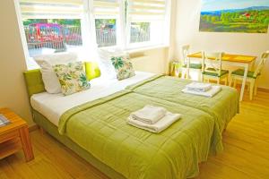 乌斯特龙Nad Stawem的一间卧室配有绿床和毛巾