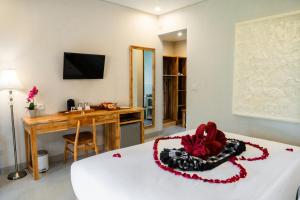 乌布Ari Cottages Ubud的客房设有一张带书桌和桌子的床。