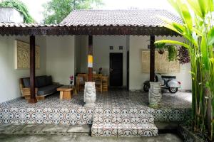 乌布Ari Cottages Ubud的一个带门廊的房子,配有沙发和摩托车