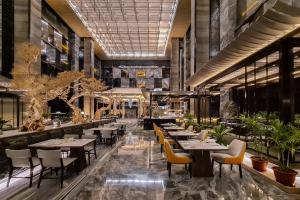 马尼拉Hotel Okura Manila - Staycation Approved的一间设有桌椅的餐厅,种植了植物