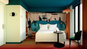 巴黎Ibis Styles Paris Batignolles的卧室配有白色的床和蓝色床头板