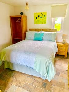 斯旺西Molehill lodge的卧室配有带蓝色枕头的大型白色床