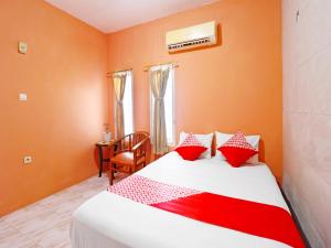 占碑市OYO 91408 Kas Residence Syariah的一间卧室配有红色和白色枕头的床