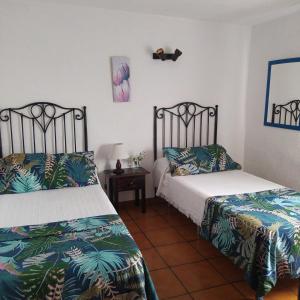 蒂哈拉费Casa Los Mangos的一间卧室配有两张床和一张带台灯的桌子