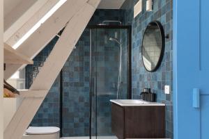 HarelbekeFarmhouse Hoeve Den Ast 5 separate bedrooms with bathrooms的浴室设有水槽、镜子和蓝色瓷砖