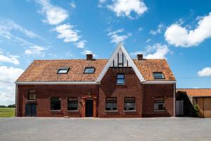 HarelbekeFarmhouse Hoeve Den Ast 5 separate bedrooms with bathrooms的红砖房子,有三角形屋顶