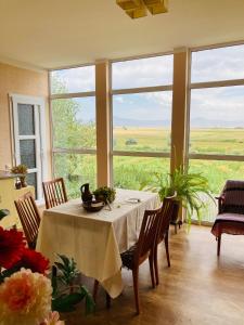 久姆里Гостевой дом с панорамными окнами的一间带桌子和大窗户的用餐室