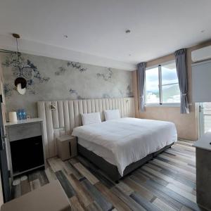 台东芙蘿拉萃旅的一间卧室设有一张大床和一个窗户。