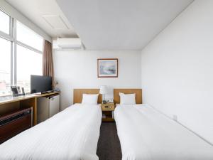 旭川Tabist THE GREEN ASAHIKAWA的一间酒店客房,设有两张床和电视