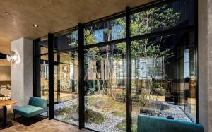 京都Prince Smart Inn Kyoto Sanjo的玻璃房子,外面有花园