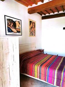 卢奇尼亚诺La Dormeuse的卧室配有一张床,墙上挂有两张照片