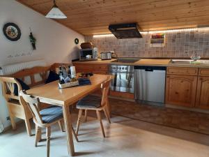 希格斯多夫Ferienwohnung am Wirtshof的厨房配有木桌和桌椅