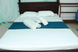 迪克韦勒Southern Entry Dickwella的一张带两条毛巾和两个枕头的床