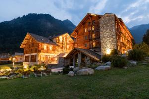 阿兰尼亚·瓦尔塞西娅Alagna Mountain Resort & SPA的一座大木结构建筑,背景是一座山