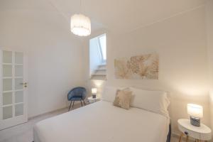 阿纳卡普里La Deliziosa的白色卧室配有床和蓝椅