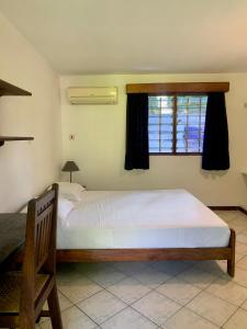 达累斯萨拉姆Baobab Village Studio的卧室设有一张白色大床和一扇窗户。