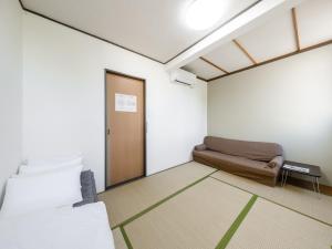 旭川Tabist Diversity Hotel Sin Tokiwa Asahikawa的一间设有床铺和沙发的房间