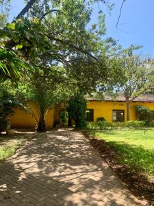 达累斯萨拉姆Baobab Village Studio的黄色建筑前的走道