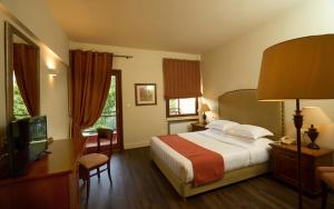波尔塔里亚森雅宫波尔塔里亚酒店的一间卧室配有一张床、一张书桌和一台电视