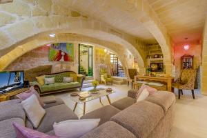 KerċemThe Valley Holiday Home的一个带石墙的大客厅