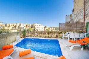 KerċemThe Valley Holiday Home的一个带椅子和桌子的游泳池