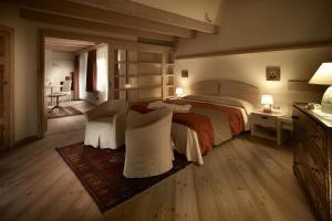 潘基阿卡斯特雷套房酒店的一间卧室配有一张大床和两把椅子