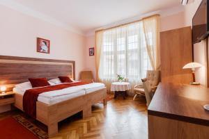 波杰布拉迪马尔卡别墅A酒店的一间卧室配有一张床、一张书桌和一个窗户。
