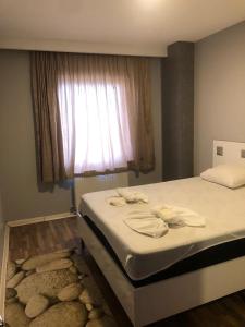 吉拉克FATIH - TUYAP APART'S的一间卧室配有一张带窗户和地毯的床