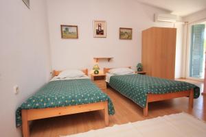 萨利Apartments and rooms by the sea Zaglav, Dugi otok - 393的一间卧室配有两张带绿床单的床