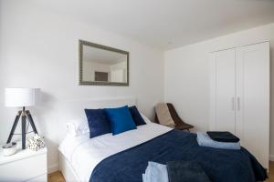 红山Gorgeous Modern Apartment near Redhill Station inc Private Garden & Parking的卧室配有蓝色和白色的床和镜子
