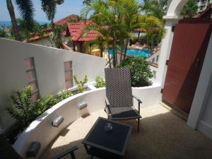 查汶苏梅岛小花园度假酒店的一个带游泳池的阳台的椅子和桌子