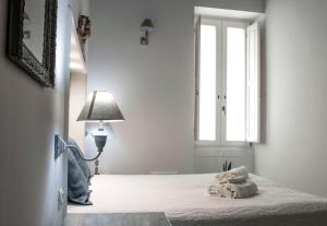 马丁纳弗兰卡Casa Vacanze L'essenziale的一间卧室配有床、灯和窗户