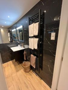 莱顿Het Waterhof的黑色浴室设有水槽和镜子