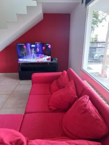 乌斯怀亚MODERNA CASA EN USHUAIA的客厅设有一张红色沙发,配有电视