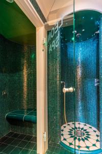 施坦贝尔格湖畔贝格莱尼赛酒店的带淋浴、卫生间和浴缸的浴室