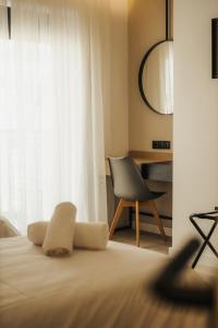 塞萨洛尼基ICON Urban Living的一间卧室配有一张带椅子的床和一扇窗户