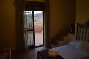 AlmogíaDoña Ana的一间卧室设有一张床,并有通往阳台的门