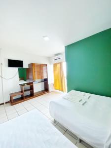 塞拉INTER HOTEL JACARAÍPE的卧室配有白色的床和绿色的墙壁