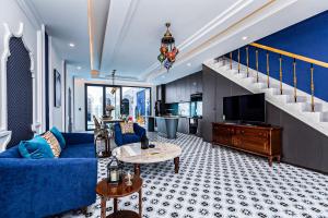 头顿T-Maison Riad Villa, with Pool, Karaoke, Billiards, near beach, Vung Tau的客厅配有蓝色的沙发和电视