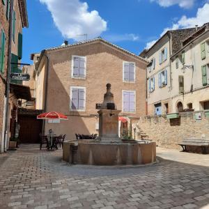 Saint-Martin-de-BrômesCampaneta的街道中间的喷泉,有一座建筑