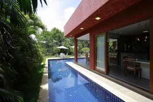 卡马萨里Casa Temporada - 4 suítes - Condomínio Luxo - Piscina Extraordinária - Praia de Itacimirim-BA的房屋旁的游泳池