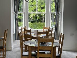 韦茅斯Lantana Guest House的一间带桌椅和窗户的用餐室