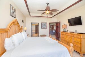 西区Del Playa Penthouse #5 Condo的卧室配有白色的床和平面电视。
