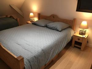 梅奥德尔Gîte La Grange的一间卧室配有一张带2个床头柜的大床