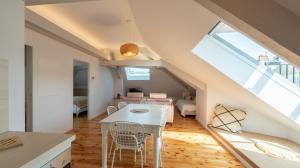 罗德兹Le Grenier Cosy, T2 classé meublé de tourisme的厨房以及带白色桌椅的起居室。