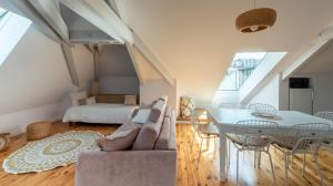 罗德兹Le Grenier Cosy, T2 classé meublé de tourisme的客厅配有沙发和桌子